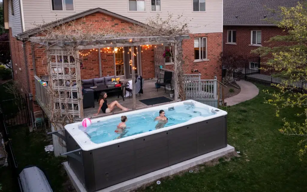 Swimlife swim spa in backyard with people playing in water